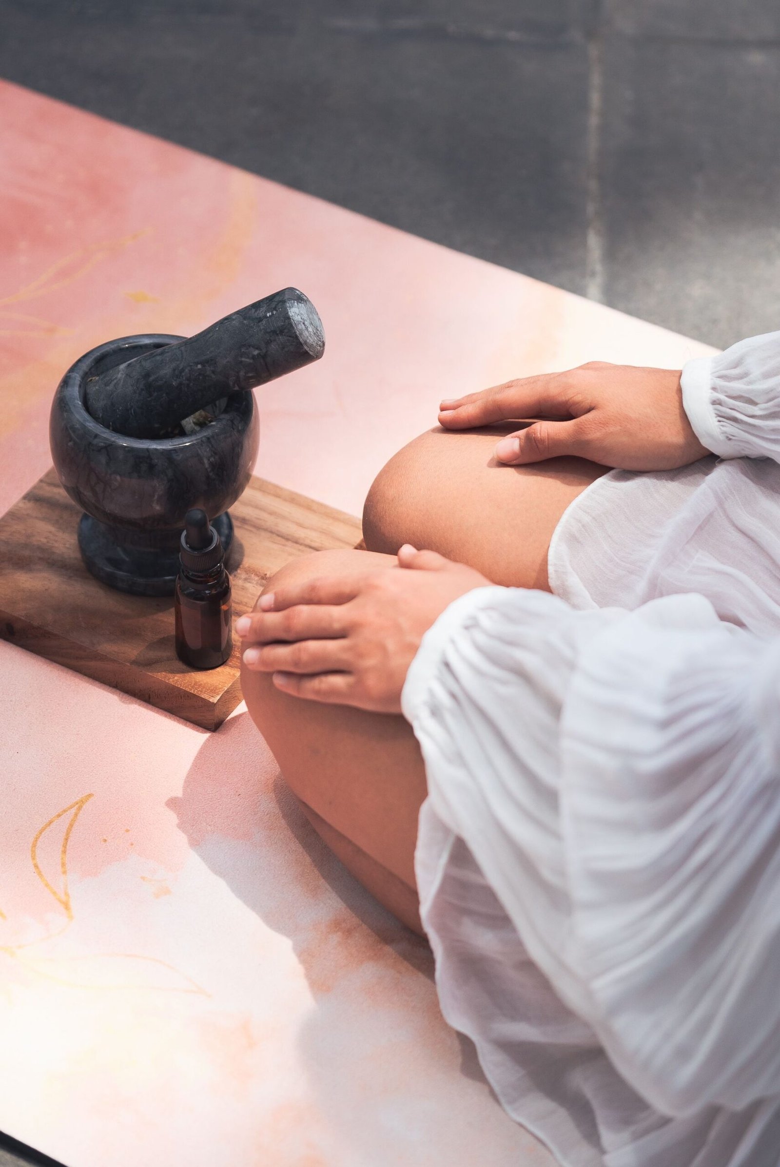 Natural oil being prepared with a stone mortar and pestle beside a treatment