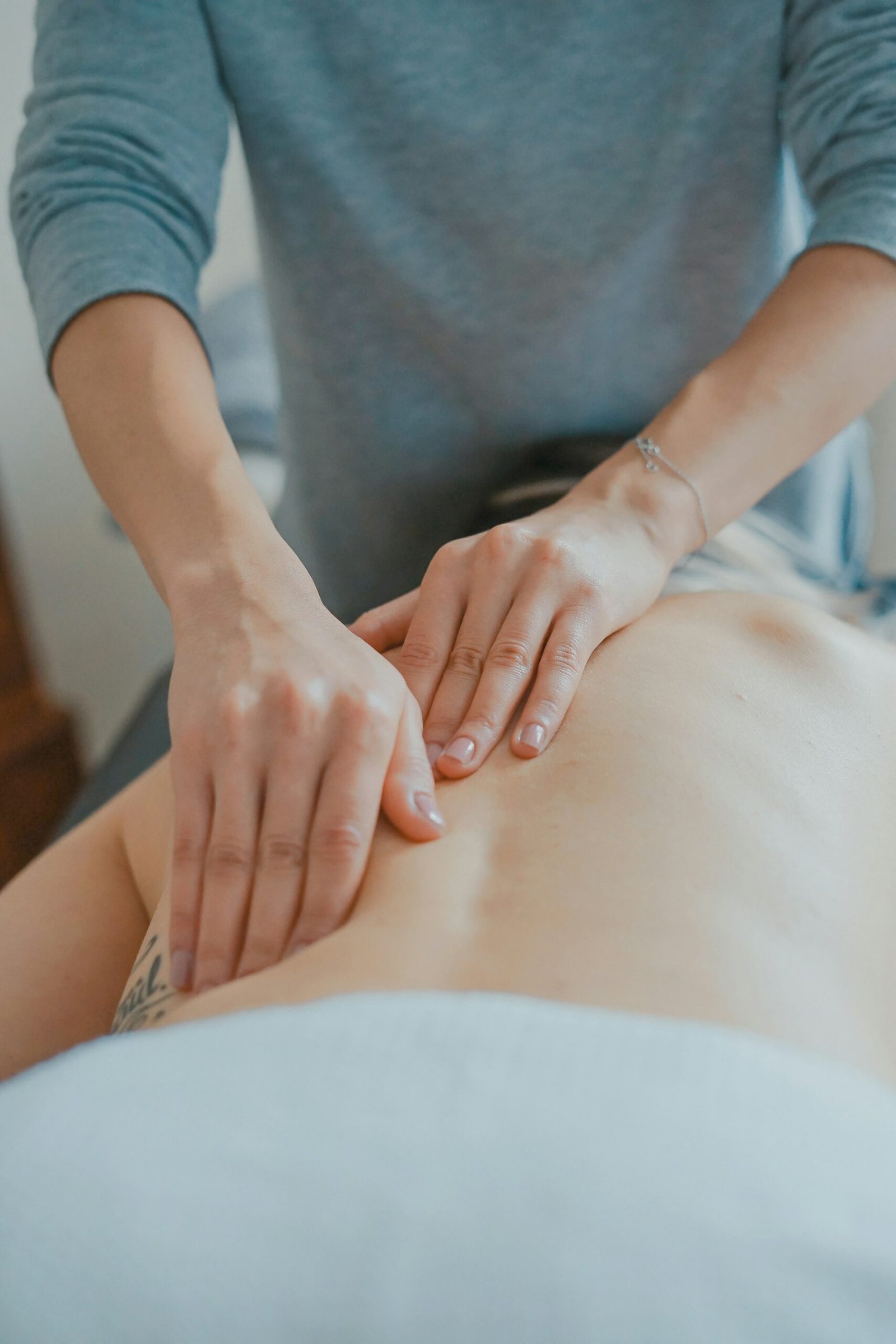 Therapist hands giving a calm back massage, natural light
