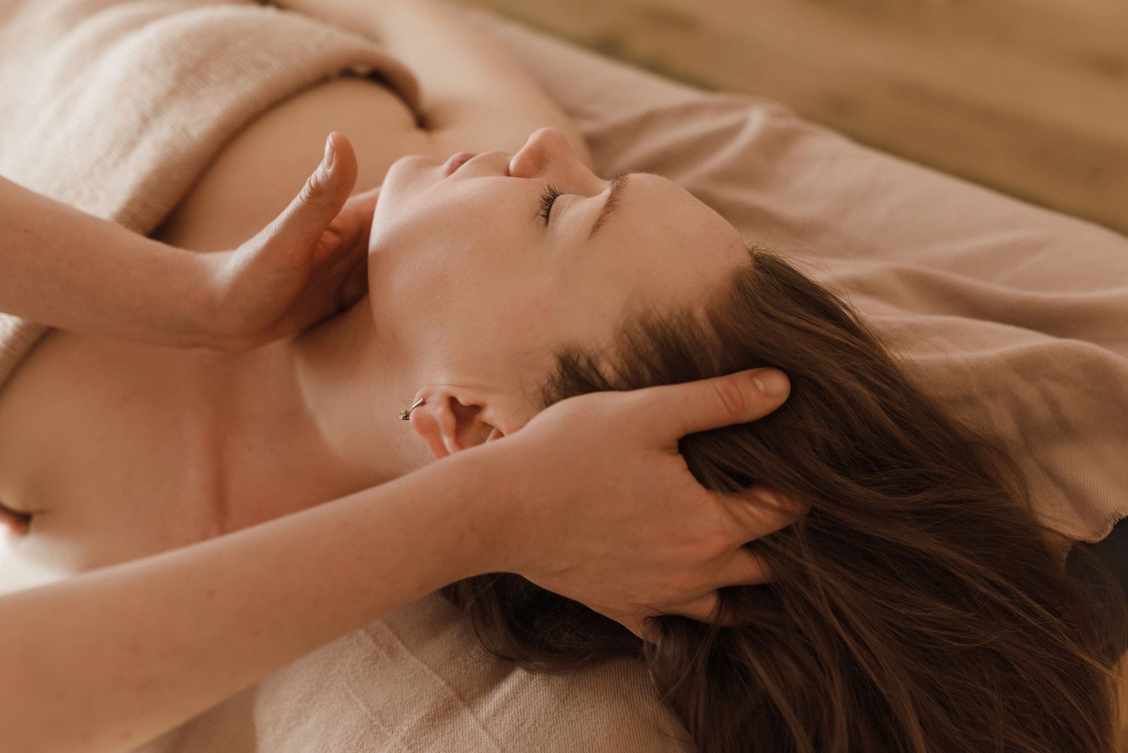 Therapist performing a focused neck and head massage on a relaxed client