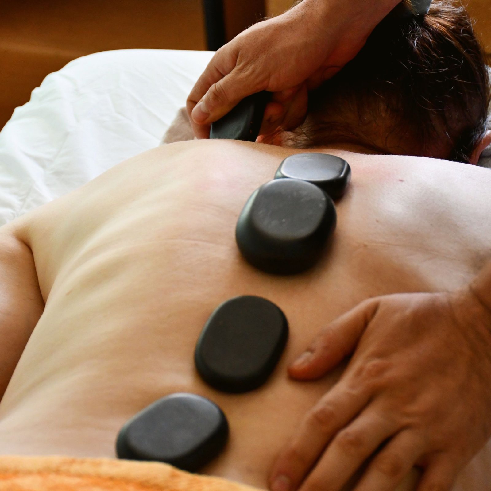 Smooth heated stones placed along the spine during a hot stone massage