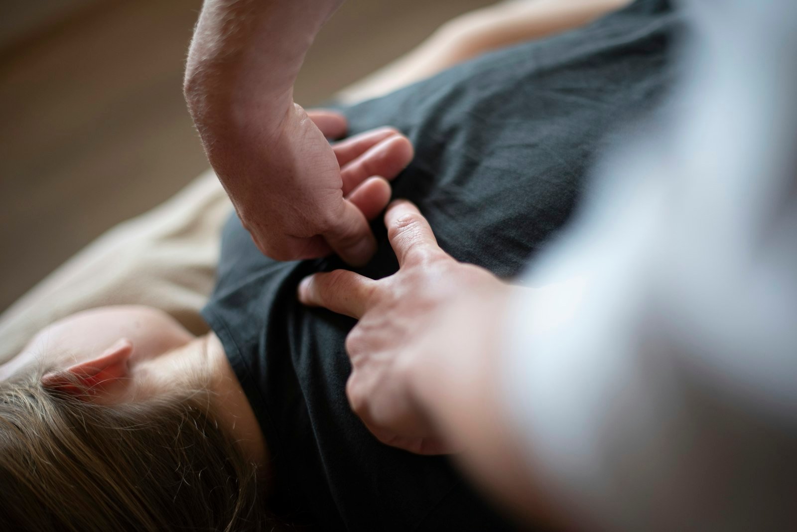 Hands pressing firmly into a person's back through fabric, therapeutic stretch